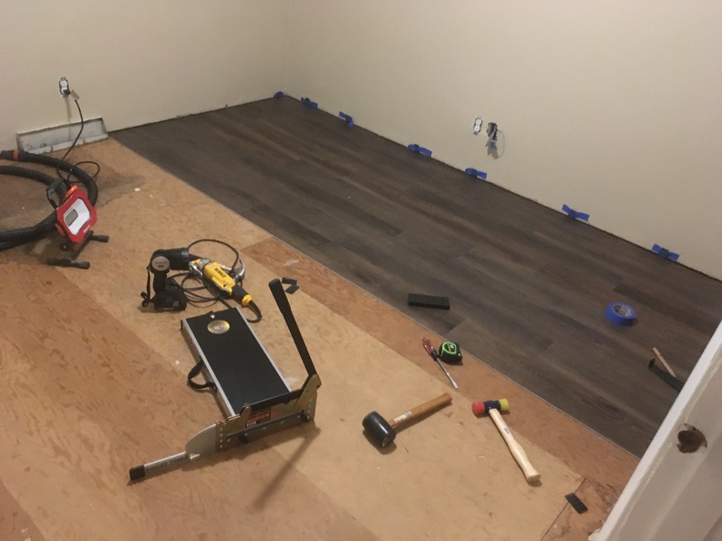 Starting to lay the vinyl plank flooring.JPG
